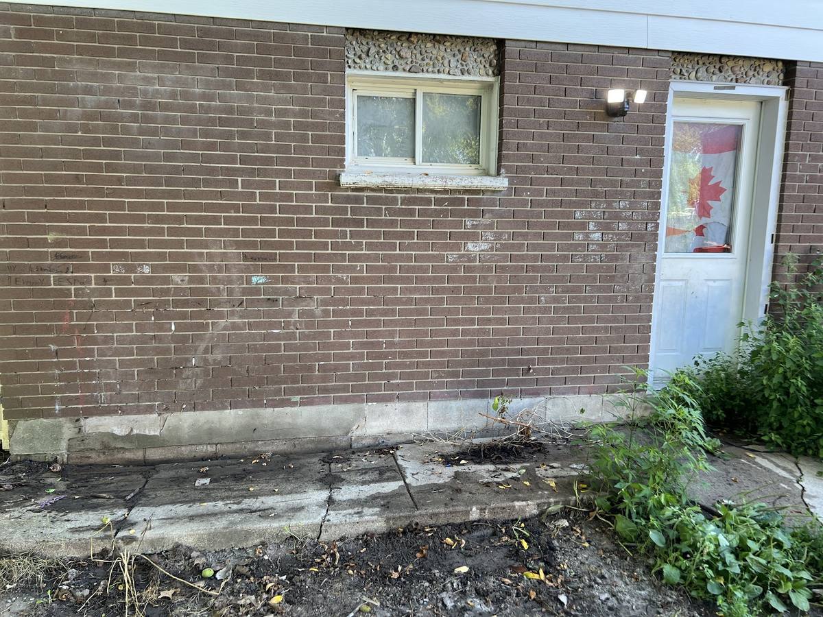 Exterior cleanup area beside a brick home