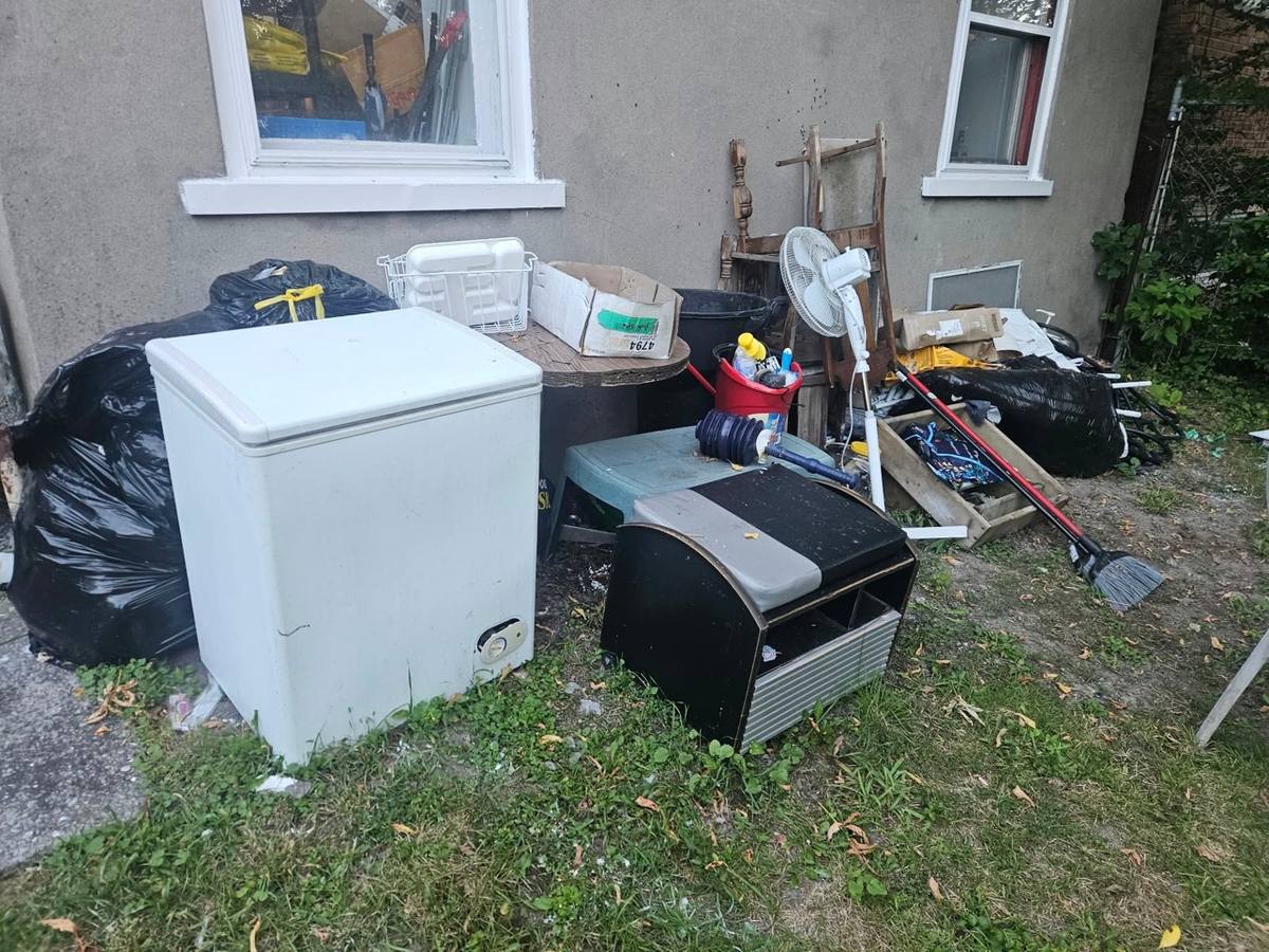 Junk pile before removal - freezer, bags and household items